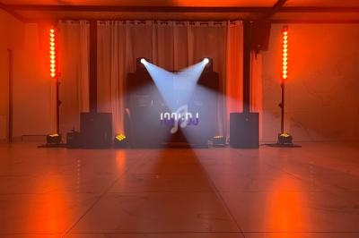 Installation de matériel de sonorisation et d'éclairage avec projecteurs lumineux dans une salle vide.