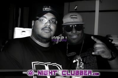 Deux hommes posent ensemble dans un environnement sombre, avec un logo ’Night Clubber’ en bas de l'image.