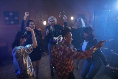 Des personnes dansent ensemble dans une ambiance festive et tamisée, éclairée par des lumières colorées.