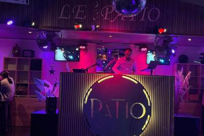 Personnes dansant dans une salle sombre éclairée par des lumières colorées, ambiance festive.