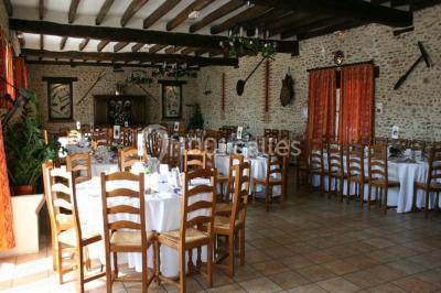 Chaises blanches empilées et disposées sur une pelouse entourée d'arbres par une journée ensoleillée.