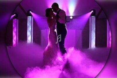 Un couple danse dans une ambiance romantique avec éclairage violet et fumée au sol.