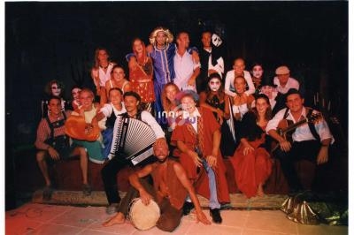 Un groupe de personnes déguisées en costumes variés, posant sur une scène dans une ambiance festive et colorée.