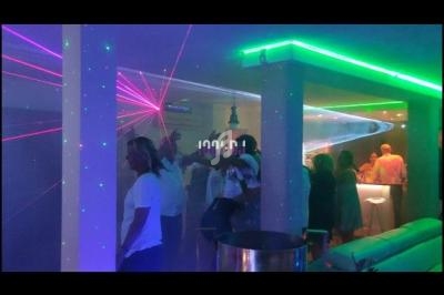 Personnes dans une discothèque avec éclairages colorés, lasers et ambiance festive.