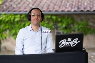 Homme portant un casque audio, assis devant une table avec un ordinateur portable et un logo ’DJ Boris Events’.