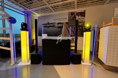 Installation de matériel de sonorisation et éclairage avec des colonnes lumineuses jaunes dans un espace intérieur moderne.