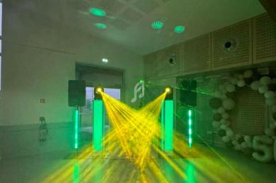 Jeux de lumières vertes et jaunes projetés dans une salle avec des enceintes et une décoration en ballons.