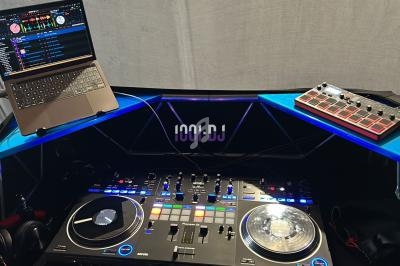 Poste de DJ avec une console de mixage, un ordinateur portable affichant un logiciel de DJ et un contrôleur MIDI.