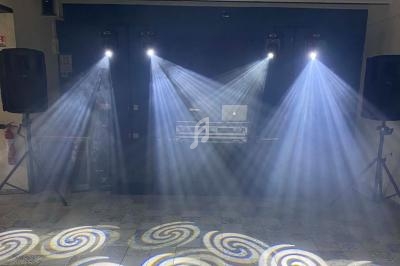 Installation de lumière de scène avec projecteurs diffusant des faisceaux lumineux sur un sol carrelé.