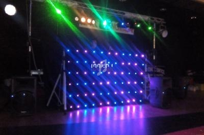 Installation de lumières LED colorées sur une scène sombre avec des haut-parleurs et une structure métallique.