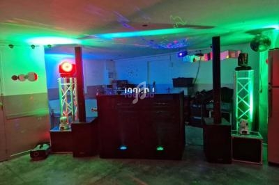 Installation de matériel de sonorisation et d'éclairage avec jeux de lumières colorées dans une salle.