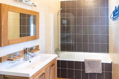 Pelouse verdoyante entourée de grands arbres sous un ciel partiellement nuageux.