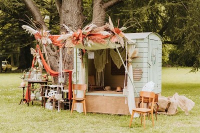 Pelouse verdoyante entourée de grands arbres sous un ciel partiellement nuageux.