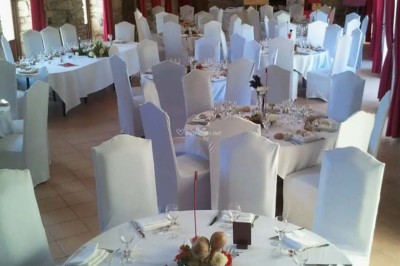 Pelouse verdoyante entourée de grands arbres sous un ciel partiellement nuageux.