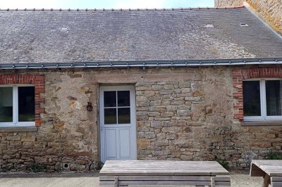 Pelouse verdoyante entourée de grands arbres sous un ciel partiellement nuageux.