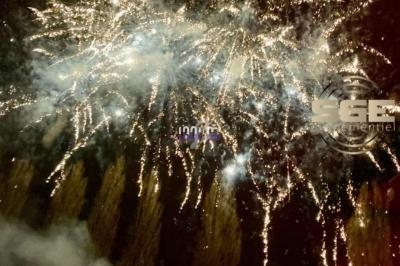 Feu d'artifice illuminant le ciel nocturne avec des éclats dorés et des traînées lumineuses.