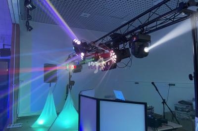 Installation de matériel d'éclairage et de sonorisation avec projecteurs colorés dans une salle intérieure.