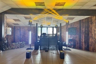 Installation de matériel de sonorisation et éclairage avec projecteurs jaunes dans une salle au décor boisé.