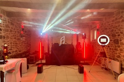 Installation de matériel de sonorisation et éclairage avec jeux de lumières dans une salle en pierre.