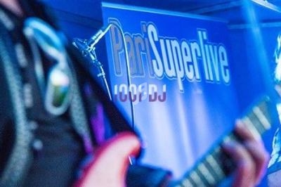 Musicien jouant de la guitare électrique sur une scène éclairée, avec une bannière ’ProSweetlive’ en arrière-plan.