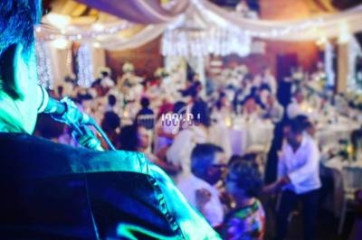 Un musicien joue du saxophone lors d'une réception festive dans une salle décorée avec des guirlandes lumineuses.