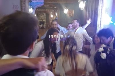 Des personnes dansent et célèbrent dans une salle décorée avec des lumières et des ornements élégants.