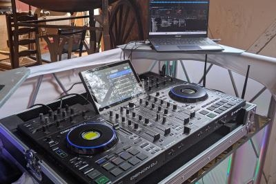 Table de mixage DJ équipée de platines et d'un ordinateur portable dans un espace intérieur lumineux.