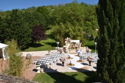 Allée bordée de pelouse et d'arbres taillés, sous un ciel dégagé dans un jardin verdoyant.