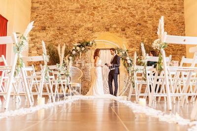 Lever de soleil illuminant un jardin avec des arbres, un muret en pierre et une vue sur un paysage brumeux.