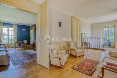 Lever de soleil illuminant un jardin avec des arbres, un muret en pierre et une vue sur un paysage brumeux.