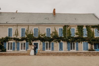 Lever de soleil illuminant un jardin avec des arbres, un muret en pierre et une vue sur un paysage brumeux.