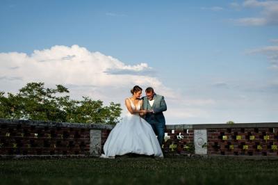 Lever de soleil illuminant un jardin avec des arbres, un muret en pierre et une vue sur un paysage brumeux.