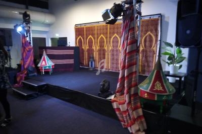 Scène décorée avec des motifs orientaux, tapisseries, lanternes et éléments traditionnels dans une salle intérieure.