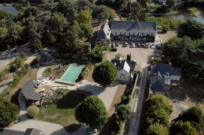 Lever de soleil sur un jardin avec des arbres, un chemin en terre et une balustrade en pierre surplombant un paysage brumeux.