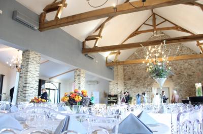 Lever de soleil sur un jardin avec des arbres, un chemin en terre et une balustrade en pierre surplombant un paysage brumeux.