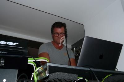 Un homme portant un casque audio mixe de la musique sur un ordinateur portable dans un environnement intérieur.