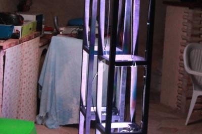 Structure métallique verticale avec éclairage LED coloré, installée dans un espace intérieur avec mobilier en arrière-plan.