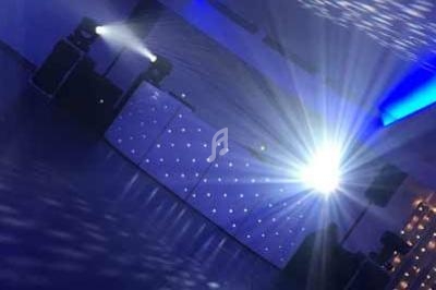 Salle de réception avec éclairage bleu et jeux de lumière projetés sur le plafond et les murs.