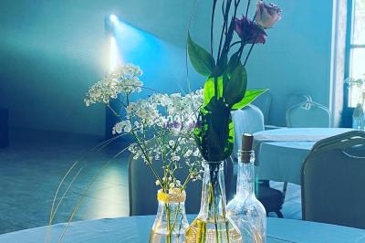 Vase avec des fleurs colorées et blanches sur une table dans une salle éclairée par une lumière tamisée.