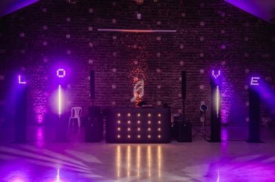 Jeu de lumières violettes et orange illuminant une scène avec le mot ’LOVE’ formé par des lettres lumineuses.