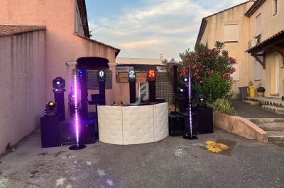 Installation de matériel de sonorisation et d'éclairage dans une cour extérieure entre deux maisons.