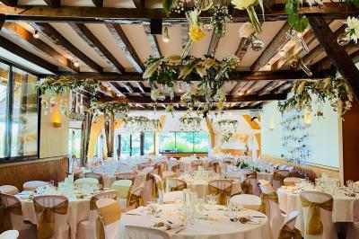 Décoration festive sous une tente avec arche lumineuse, sapins de Noël, guirlandes et sol en bois.