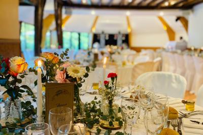 Décoration festive sous une tente avec arche lumineuse, sapins de Noël, guirlandes et sol en bois.