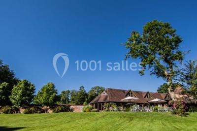 Décoration festive sous une tente avec arche lumineuse, sapins de Noël, guirlandes et sol en bois.