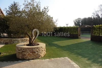 Chambre mansardée avec un lit double blanc, parquet au sol, mur beige et lumière naturelle provenant d'une porte-fenêtre.