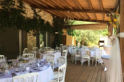 Salle de réception décorée avec des guirlandes lumineuses, des lanternes suspendues et des tables dressées pour un événement.
