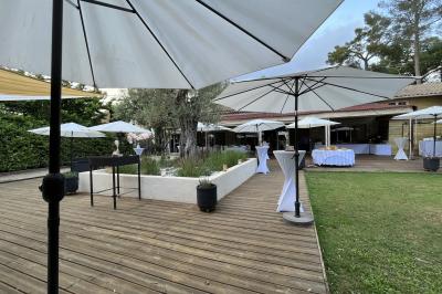 Salle de réception décorée avec des guirlandes lumineuses, des lanternes suspendues et des tables dressées pour un événement.