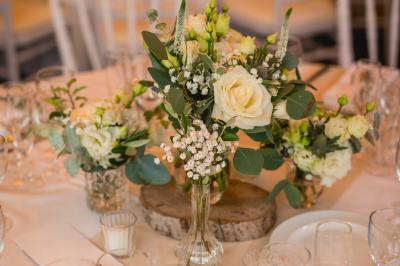 Salle de réception décorée avec des guirlandes lumineuses, des lanternes suspendues et des tables dressées pour un événement.