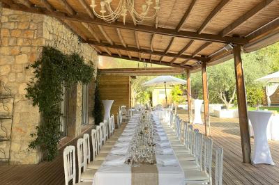 Salle de réception décorée avec des guirlandes lumineuses, des lanternes suspendues et des tables dressées pour un événement.