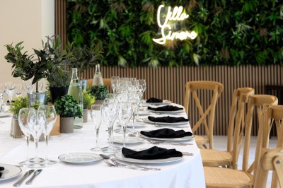Table décorée pour un événement avec un arbre blanc central orné de boules transparentes et des verres disposés autour.